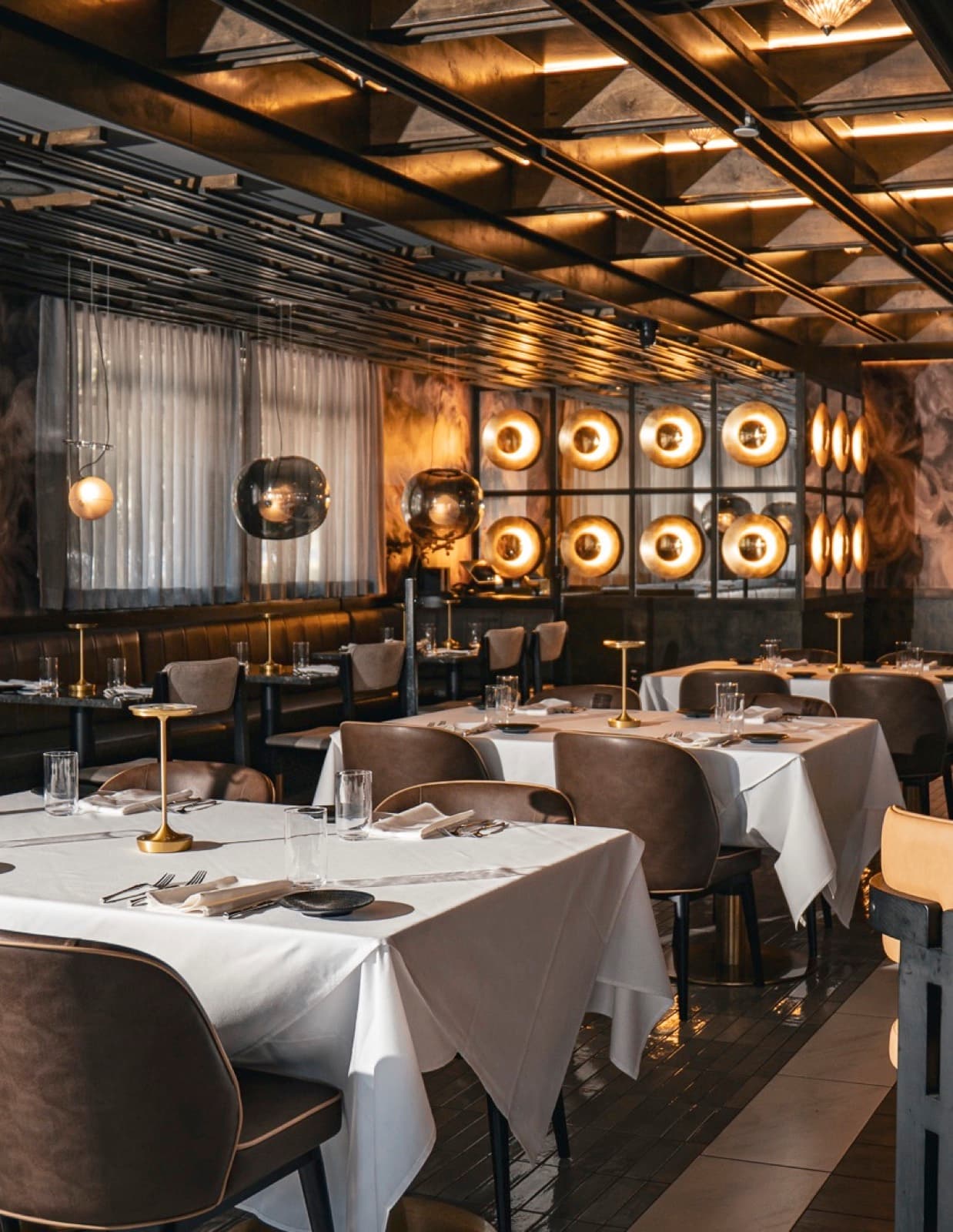 Private dining room at Fuego Vivo — brass ceiling and backlit wall